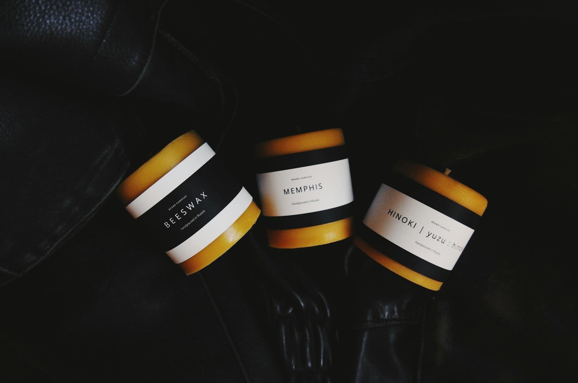 Eleganckie świece zapachowe w ciemnej aranżacji, minimalistyczne etykiety Eleganckie świece zapachowe w ciemnej aranżacji, minimalistyczne etykiety