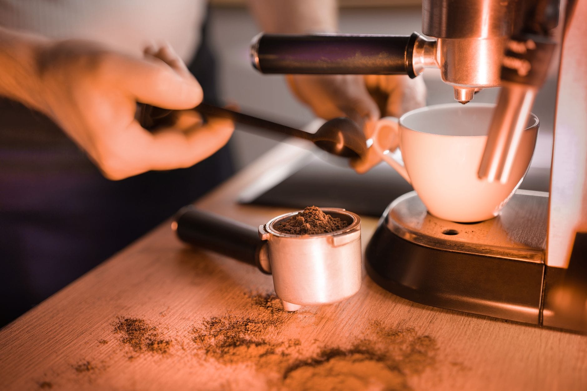 Barista przygotowuje espresso z świeżo mielonej kawy na ekspresie